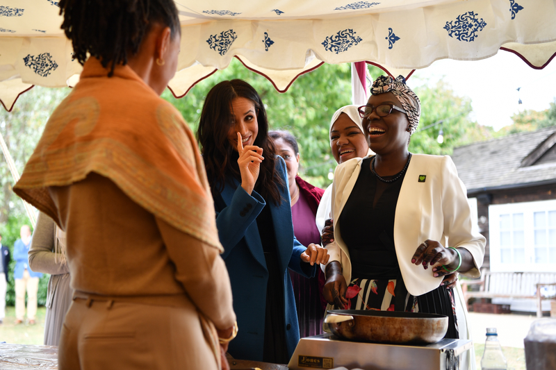 Meghan, Duchess of Sussex (C) jokes with her mother Doria Ragland (L) at an event to mark the launch of a cookbook with recipes from a group of women affected by the Grenfell Tower fire on Sept. 20, 2018 in London, England.